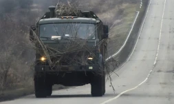 Un camion militaire russe avance sur une route dans la région de Rostov, frontalière du territoire séparatiste de Donetsk dans l'Est de l'Ukraine, le 23 février 2022