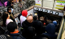 Des voyageurs attendent que les grilles du métro s'ouvrent le 20 décembre 2019 à la station Porte d'Orléans à Paris