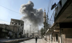 De la fumée s'élève au-dessus d'un bâtiment après des bombardements sur la ville de Hamouria, dans l'enclave rebelle de la Ghouta orientale, près de Damas le 21 février 2018