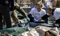 Des soldats ukrainiens enveloppent les corps des victimes d'une attaque de missiles russes sur la gare de Kramatorsk, le 8 avril 2022 dans la régin du Donbass, dans l'est de l'Ukraine