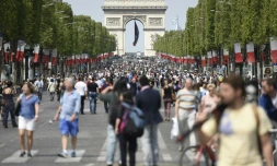 Des passants sur l'avenue des Champs-Elysées à Paris le 8 mai 2016 à l'occasion d'une journée sans voiture désormais chaque premier du dimanche du mois pour lutter contre la pollution