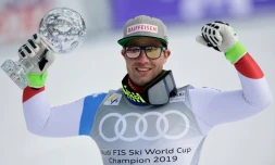Le Suisse Beat Feuz pose avec le globe de la descente, à l'issue de la descente de Coupe du monde de Soldeu en Andorre, le 13 mars 2019
