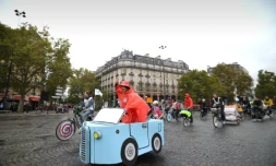 Une femme conduit une voiture en carton place de la Bastille à Paris lors de la journée sans voiture, le 1er octobre 2017