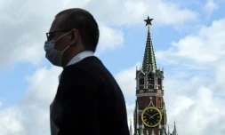 Un homme portant un masque passe devant le Kremlin, à Moscou, le 12 août 2020