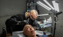 Remy, tatoueur professionnel, réalise une intervention de micropigmentation du cuir chevelu sur un client, dans son studio de Ginowan, à Okinawa au Japon, le 19 mai 2026