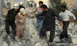Des secouristes syriens aident une femme blessée à se sortir des décombres, après une frappe aérienne des forces gouvernementales contre le quartier d'Hadariya tenu par les rebelles, le 10 avril 2016 à Alep