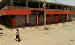 Un Soudanais marche devant des magasins fermés dans une rue déserte de la capitale Khartoum, le 10 juin 2019