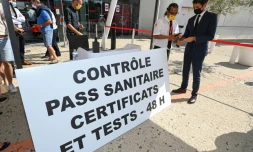 Le porte-parole du gouvernement Gabriel Attal (D) présente son pass sanitaire lors d'une visite dans un cinéma de Montpellier le 29 juillet 2021