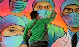 L'artiste mexicain Sergio Morelos, plus connu sous le nom Applezman, peint une fresque en hommage au personnel soignant, à Mexico le 25 août 2020