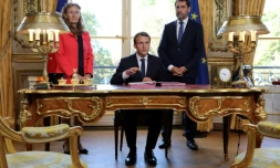 Le président Emmanuel Macron, entouré par la ministre de la Justice Nicole Belloubet et le porte-parole du gouvernement, Christophe Castaner, s'apprête à signer les deux lois de moralisation de la vie politique, le 15 septembre 2017 à l'Elysée, à Paris