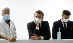 Le président français Emmanuel Macron (au centre), le ministre de la Santé Olivier Veran (à droite) et Jan Hayon (à gauche), le médecin chef des soins intensifs de l'hôpital de Poissy (France), discutent avec le personnel soignant, le 17 mars 2021
