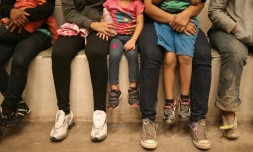 Des femmes et des enfants assis dans une cellule de détention à la frontière américano-mexicaine le 8 septembre 2014