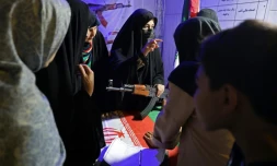 Des Iraniennes apprennent le maniement des armes dans un stand sur la place Hafter Tir de Téhéran, le 17 mai 2026