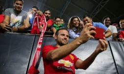 L'attaquant de Manchester United Juan Mata prend des photos avec des supporters après un match de pré-saison contre les Mexicains de Club America, le 19 juillet 2018 à Glendale près de Phoenix
