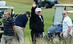 Le président américain Donald Trump (c) sur le parcours de golf de son luxueux complexe hôtelier de Turnberry, le 14 juillet 2018 en Ecosse