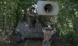 Des soldats ukrainiens installent un filet de camouflage sur un obusier automoteur M109 de 155 mm, le 10 juillet 2023 dans la région de Donetsk