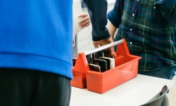 Un élève dépose son smartphone dans une boîte spéciale au début de la journée au collège Kungsvägens skola, le 21 août 2025 à Sipoo, en Finlande