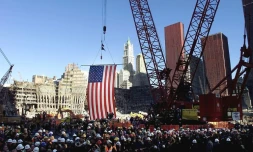 Le drapeau américain suspendu à une grue au-dessus de "Ground Zero" lors d'une cérémonie commémorative, le 11 novembre 2001 à New York, sur le site du World Trade Center détruit par des attentats le 11 septembre 2001