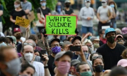 Des manifestants blancs, l'un armé d'une pancarte disant "le silence blanc tue", lors d'une manifestation à Brooklyn le 5 juin 2020