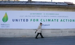 Un homme passe devant un panneau annonçant la tenue de la conférence de Paris (COP 21) sur le climat, le 14 janvier 2015