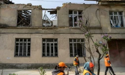 Des employés municipaux nettoient les dégâts causés par une frappe russe sur une école maternelle à Odessa en Ukraine le 30 avril 2026