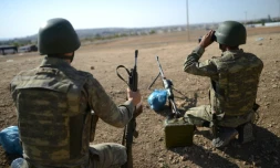 Un soldat turc surveille Ă l'aide de jumelles la frontiĂšre avec le nord de la Syrie, prĂšs de Mursitpinar, depuis la ville de Suruc, le 4 octobre 2014