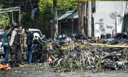 Des policiers et des soldats inspectent les lieux d'une attaque devant l'Église pentecôtiste du centre de Surabaya, en Indonésie, le 13 mai 2018