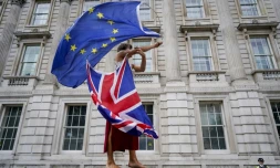 Un manifestant anti-Brexit fait tournoyer des drapeaux européen et britannique lors d'une manifestation à Londres le 31 août 2019