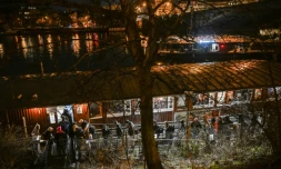 Des personnes font la queue pour passer la nuit sur l'Hermes, une péniche amarrée près de l'un des nombreux ponts qui enjambent la rivière Vltava à Prague, où le nombre de sans-abri connaît une augmentation inquiétante, le 26 janvier 2026
