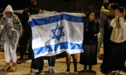 Des personnes brandissant des drapeaux israéliens accueillent l'arrivée des ex-otages du Hamas, le 1er décembre 2023 devant la base militaire d'Ofakim, dans le sud d'Israël