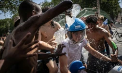 Un groupe d'adolescents asperge d'eau un jeune homme circulant en scooter près du canal Saint-Martin, à Paris, le 24 juin 2026