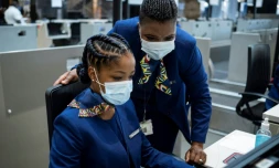 Des employés de la compagnie aérienne sud-africaine SAA au comptoir d'embarquement de l'aéroport international O.R. Tambo de Johannesburg, le 23 september 2021