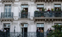 Des parisiens sur leur balcon chantent ensemble, le 1er mai 2020