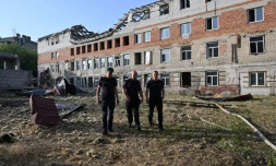 Des secouristes devant un immeuble résidentiel endommagé par une attaque de drone russe, dans le centre de Kharkiv, le 11 juillet 2025 en Ukraine