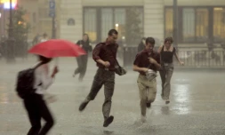 Des personnes courent dans les rues de Paris afin de se mettre à l'abri de la pluie lors d'un orage le 23 juin 2005