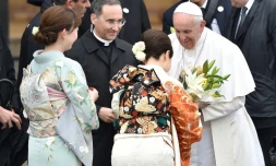 Le pape reçoit des fleurs offertes par des femmes en kimonos à son départ de l'aéroport de Tokyo, le 26 novembre 2019