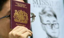 Un militant brandit un passeport britannique devant un portrait de Simon Cheng, le 21 août 2019 devant le consulat de Grande-Bretagne à Hong Kong