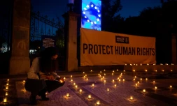 Une femme allume une bougie pendant une veillĂ©e d'Amnesty International le 6 mai 2021 devant le lieu oĂč se tiendra le "sommet social" Ă Porto.