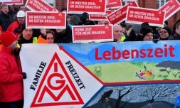 Des ouvriers de l'usine Bombardier brandissent des panneaux au logo du syndicat allemand de la métallurgie IG Metall, à Hennigsdorf près de Berlin (nord-est), le 8 janvier 2018