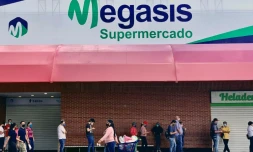Des clients font la queue devant le supermarché Megasis à Caracas le 31 juillet 2020