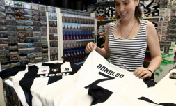 Une vendeuse propose le maillot de Cristiano Ronaldo aux couleurs de la Juventus dans une boutique du centre ville de Turin, le 11 juillet 2018