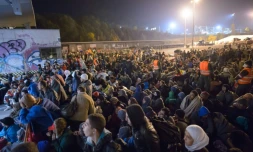 Migrants et réfugiés attendent de monter dans un bus le 23 octobre 2015 à Sentilj à la frontière entre la Slovénie et l'Autriche