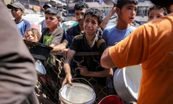 Des enfants palestiniens font la queue pour recevoir des repas d'une organisation caritative à Gaza-ville, le 14 juillet 2025