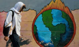 Un passant marche devant une peinture murale en pleine vague de chaleur à Varanasi, en Inde, le 9 juin 2025