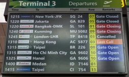 Un tableau d'information indique que le vol TP8418 d'Air Portugal à destination de Londres Heathrow est annulé à l'aéroport Changi de Singapour, le 21 mars 2025