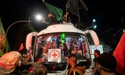 Une foule entoure un bus de la Croix-Rouge qui transporte des Palestiniens libérés de prisons israéliennes, le 26 novembre 2023 à Ramallah