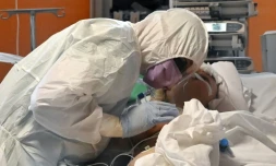 Un membre du  personnel soignant autour d'un patient atteint du nouveau coronavirus au service des soins intensifs de l'hôpital Casalpalocco près de Rome, le 24 mars 2020