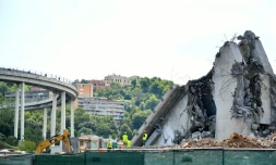 Des ouvriers sur le site et aux cĂŽtĂ©s de dĂ©bris du pont Morandi de GĂȘnes, le 13 aoĂ»t 2019, la veille du premier anniversaire de son effondrement