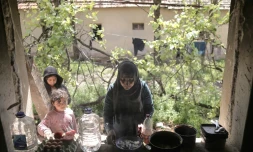 Seror Alhayani, mÚre irakienne de quatre enfants, prépare un repas dans une maison abandonnée du village serbe de Majdan, qu'ils occupent, prÚs de la frontiÚre avec la Hongrie et la Roumanie, le 21 mai 2021