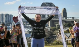 L'ex-footballeuse britannique Fran Hurndall entourée de supporteurs après avoir bouclé une course de charité de 3.800 kilomètres à travers l'Australie, le 29 juin 2025 à Sydney
